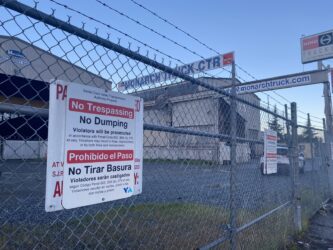 Monarch location An industrial warehouse locked behind a chain fence.