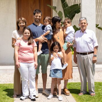 A multigenerational family standing in front of their home