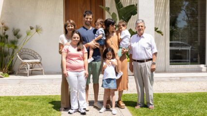 A multigenerational family standing in front of their home