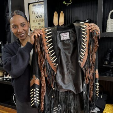 A woman holding a jacket in a clothing store in San Jose, California