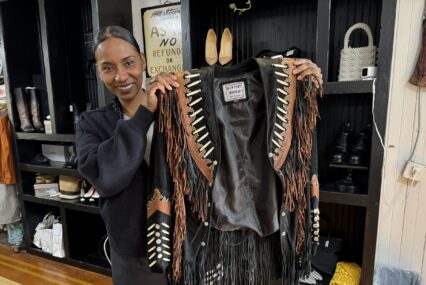 A woman holding a jacket in a clothing store in San Jose, California