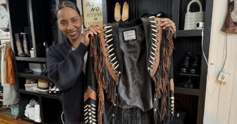 Una mujer sosteniendo una chaqueta en una tienda de ropa en San José, California.