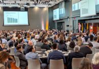 A crowd of people seated at tables watching a man speak onstage in San Jose, California