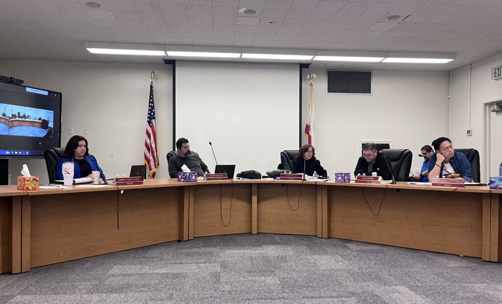 A group of men and women sitting behind dais at a school board meeting in San Jose, California