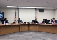 A group of men and women sitting behind dais at a school board meeting in San Jose, California