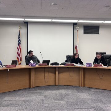 A group of men and women sitting behind dais at a school board meeting in San Jose, California