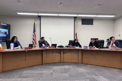 A group of men and women sitting behind dais at a school board meeting in San Jose, California