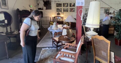 A woman looking at furniture in a thrift shop in San Jose, California