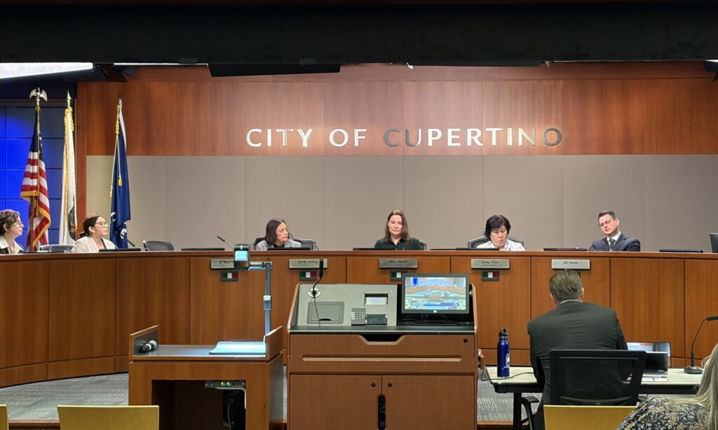 Members of a city council behind the dais at a government meeting in Cupertino, California