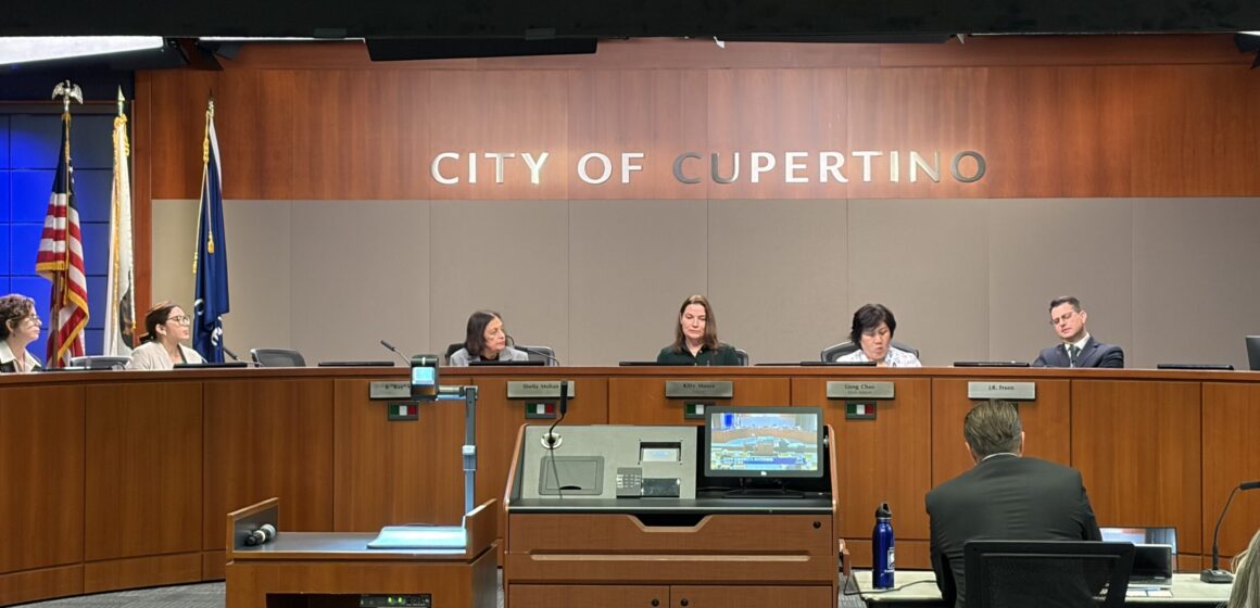 Members of a city council behind the dais at a government meeting in Cupertino, California