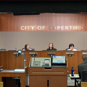 Cupertino City Council 3-17 Members of a city council behind the dais at a government meeting in Cupertino, California