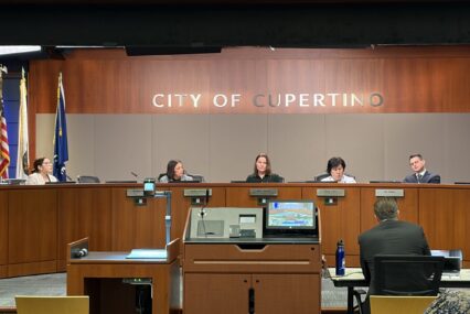 Members of a city council behind the dais at a government meeting in Cupertino, California