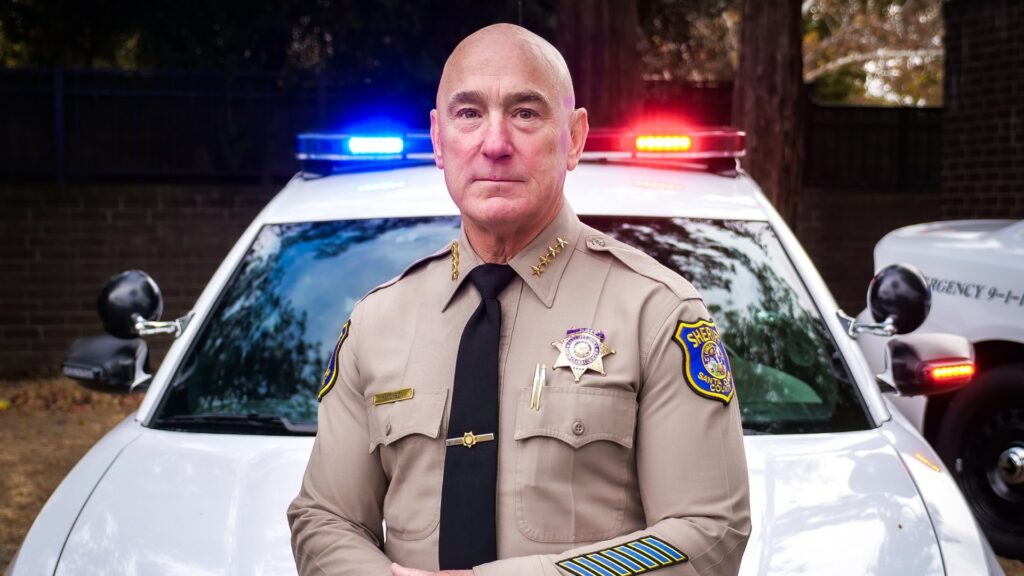 man next to police car