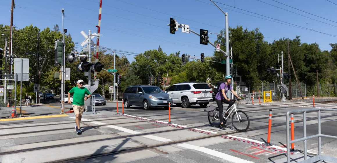 Pedestrians and cars crossing train tracks in Palo Alto, California
