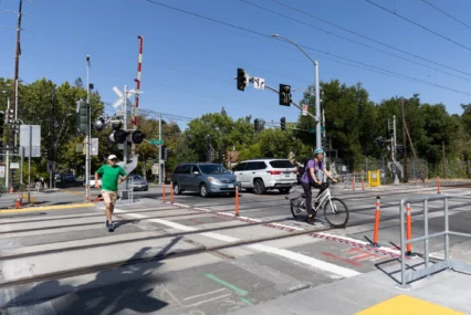 Pedestrians and cars crossing train tracks in Palo Alto, California