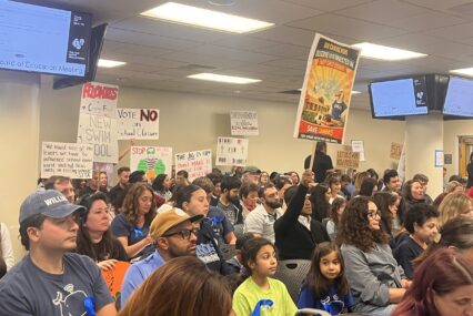 Una multitud de personas en una reunión de la junta escolar en San José, California.