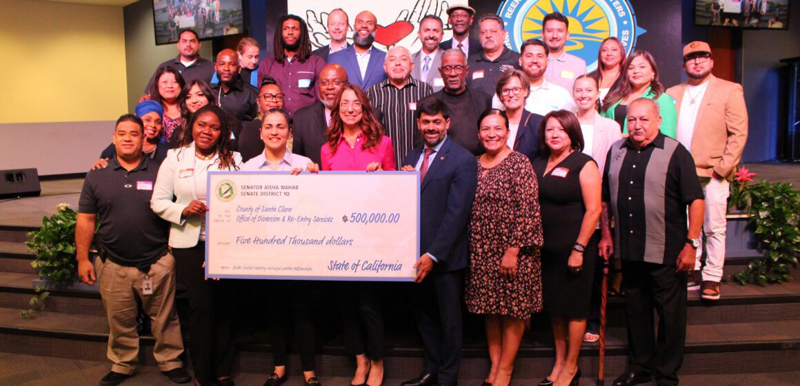 A group of people being presented with a giant check