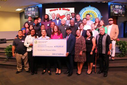 A group of people being presented with a giant check