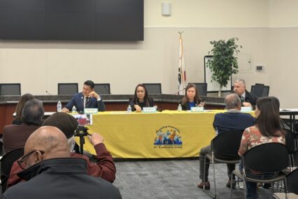 Four candidates sitting at a yellow table