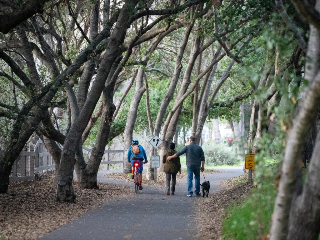 People walking on a trail near a creek in Mountain View, California