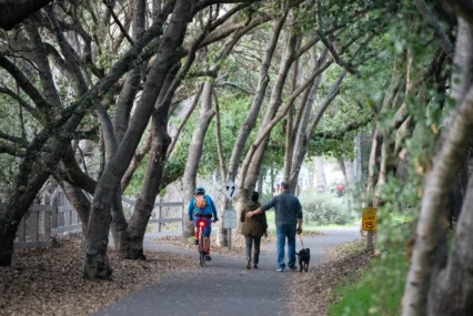 People walking on a trail near a creek in Mountain View, California