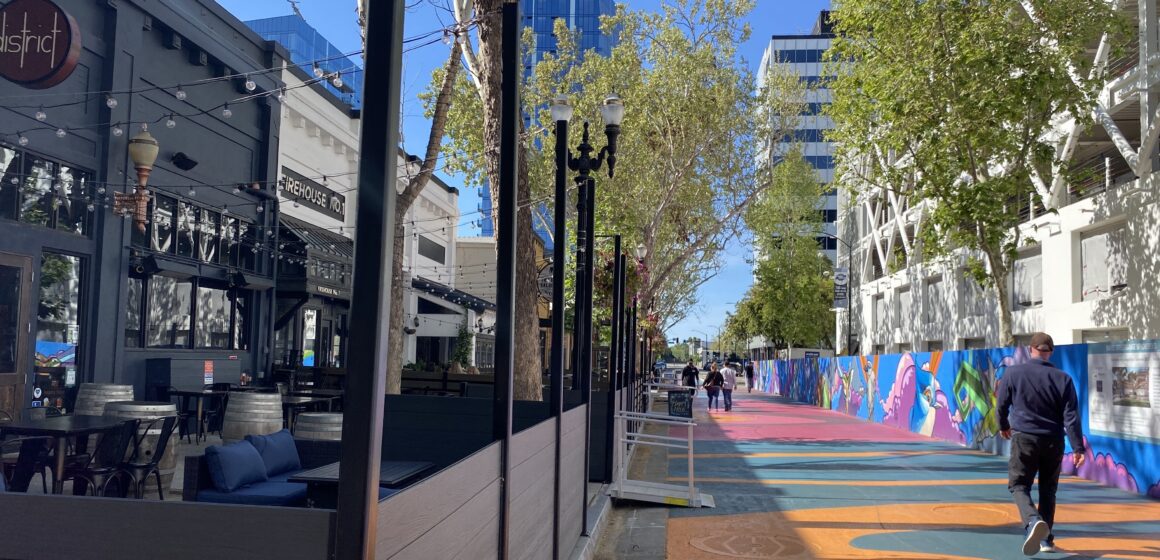 Pedestrians walk by outdoor dining spaces in San Jose, California