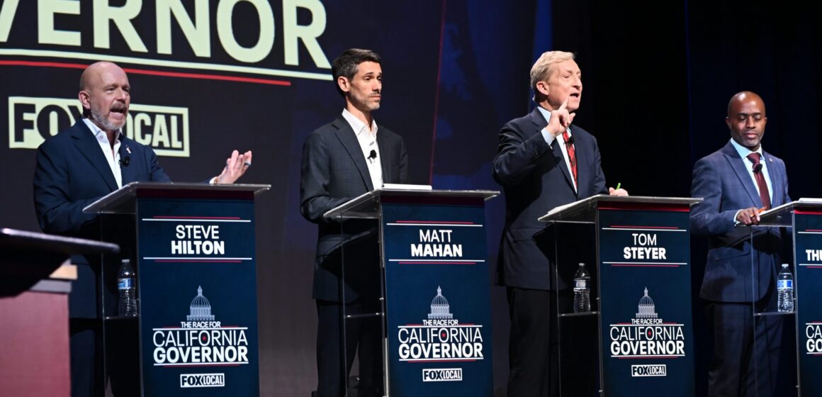 A group of candidates for California governor stand behind podiums on a stage during a debate
