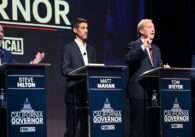 A group of candidates for California governor stand behind podiums on a stage during a debate