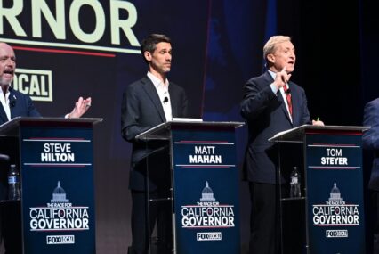 A group of candidates for California governor stand behind podiums on a stage during a debate