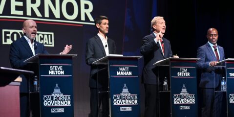 A group of candidates for California governor stand behind podiums on a stage during a debate