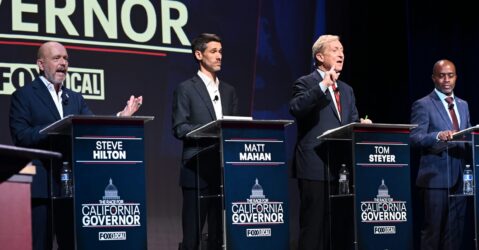 A group of candidates for California governor stand behind podiums on a stage during a debate
