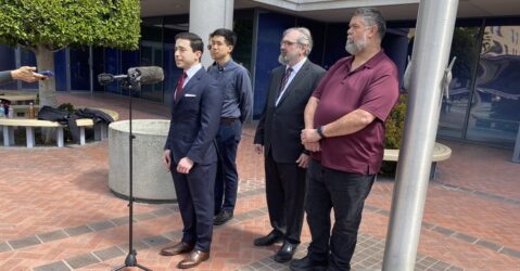 A group speaks in front of a court building in San Jose, California