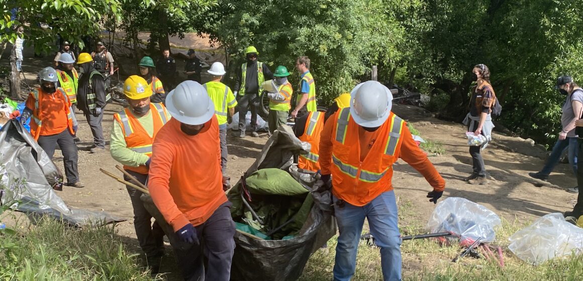 Workers clear a homeless encampment in San Jose