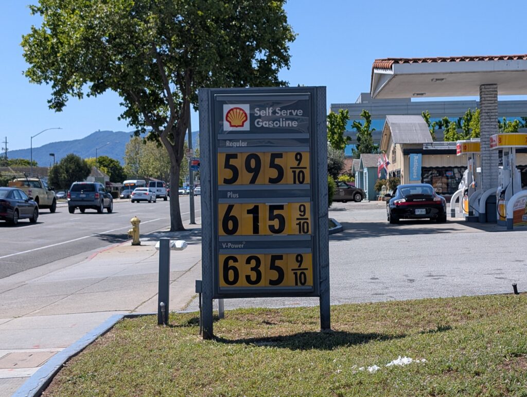 A sign at a gas station displaying prices