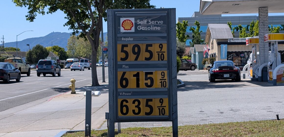 A sign at a gas station displaying prices