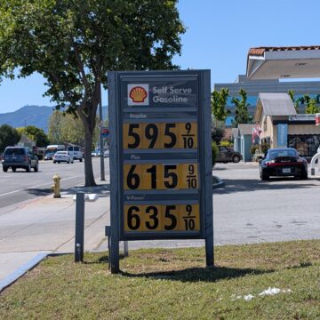 A sign at a gas station displaying prices