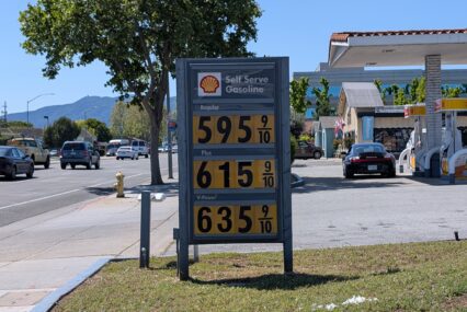 A sign at a gas station displaying prices
