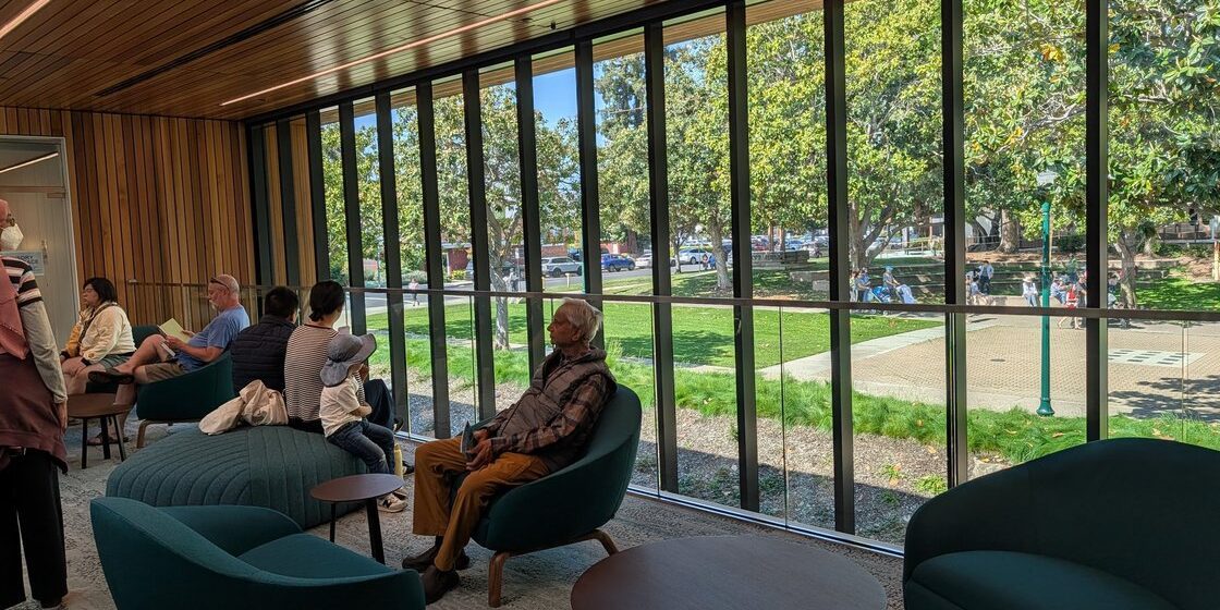 People sitting in chairs near a window at a library in Campbell, California