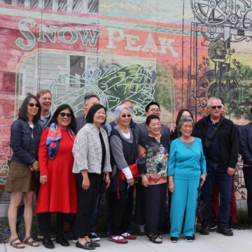 Un grupo de personas de pie frente a un mural en Palo Alto, California.