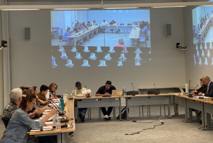 People sit at tables in a government meeting in San Jose, California