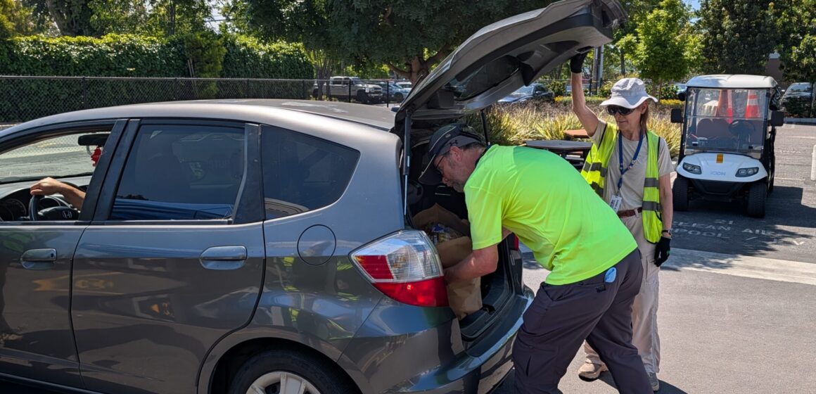 A person loads a bag of groceries into the back of a car in San Jose, California