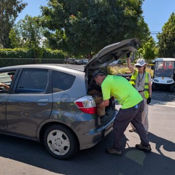 EAN CẦN HỖ TRỢ Một người đang chất một túi hàng tạp hóa vào cốp sau xe ô tô ở San Jose, California.
