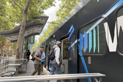 People boarding a light rail train in downtown San Jose, California