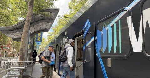 People boarding a light rail train in downtown San Jose, California