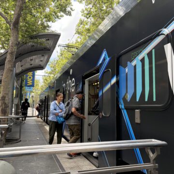 People boarding a light rail train in downtown San Jose, California