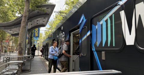 People boarding a light rail train in downtown San Jose, California