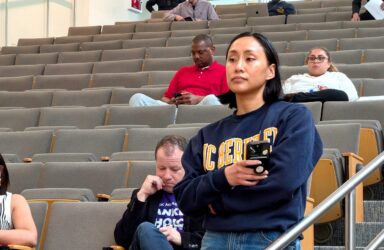 Ellina Yin council 1 A woman holding a phone waiting to speak at a public meeting