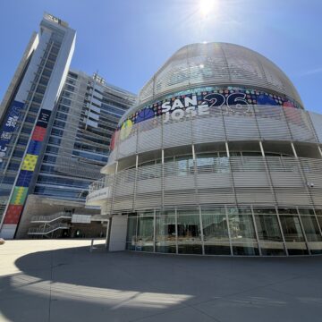 A women walks in front of a large government building in San Jose, California