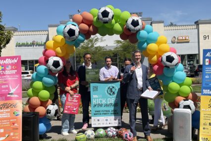 People standing in front of a balloon arch in San Jose, California