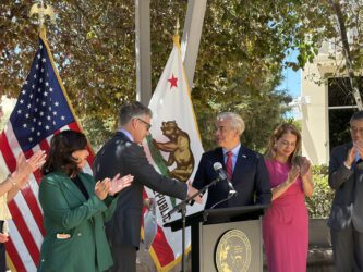 ICE FACILITY Two men shaking hands at a podium at a government press conference in San Jose, California